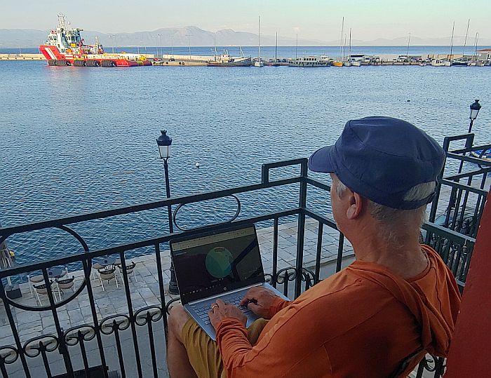 digital nomad working on a hotel balcony in Greece